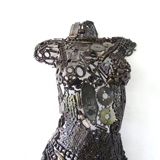 Détail de la poitrine d'une sculpture féminine en métal recyclé assemblé à la main, texture de soudure apparente