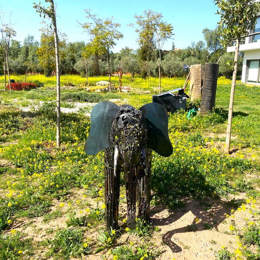 Vue de face sculpture éléphant en métal recyclé avec assemblage artisanal et textures métalliques visibles
