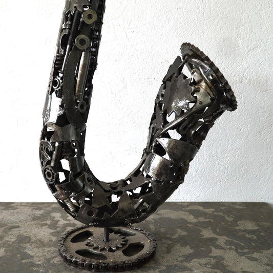 Détail culasse saxophone en métal recyclé montrant l’assemblage manuel et les reliefs métalliques