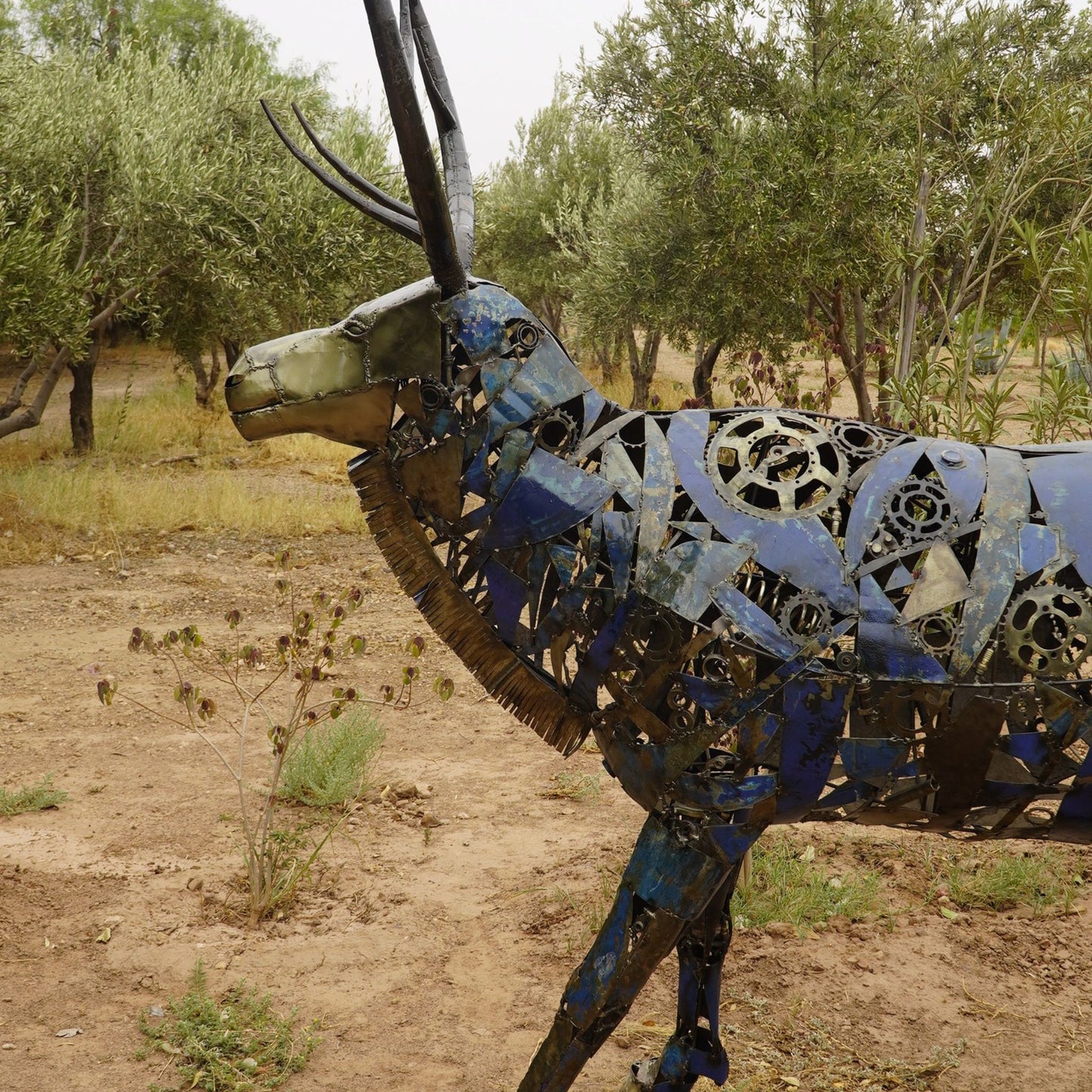 sculpture cerf métal recyclé, statue cerf décoration jardin, cerf en fer forgé, art animalier en métal, sculpture extérieure cerf, cerf décoratif métal recyclé, sculpture cerf fait main, décoration cerf style industriel, cerf géant en métal, œuvre écologique en métal recyclé, sculpture contemporaine cerf, animal en métal pour jardin, cerf artistique extérieur.