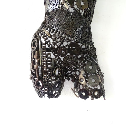 Détail du bas de la sculpture demi-buste en métal recyclé, assemblage artisanal des jambes et finition brute naturelle