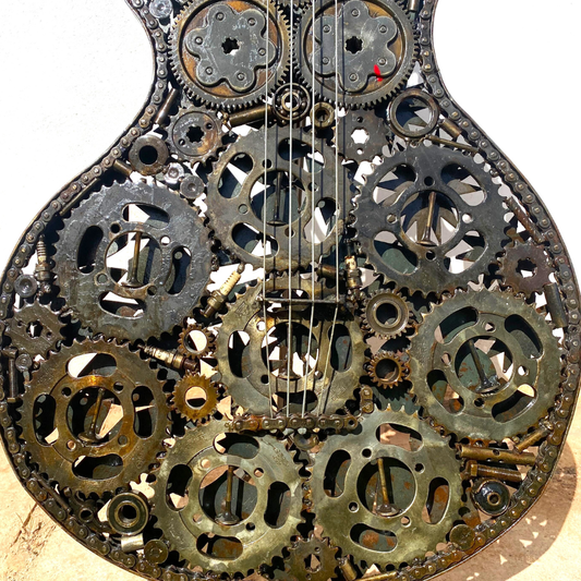 Détail finition sculpture guitare en métal recyclé avec textures brutes et nuances métalliques naturelles