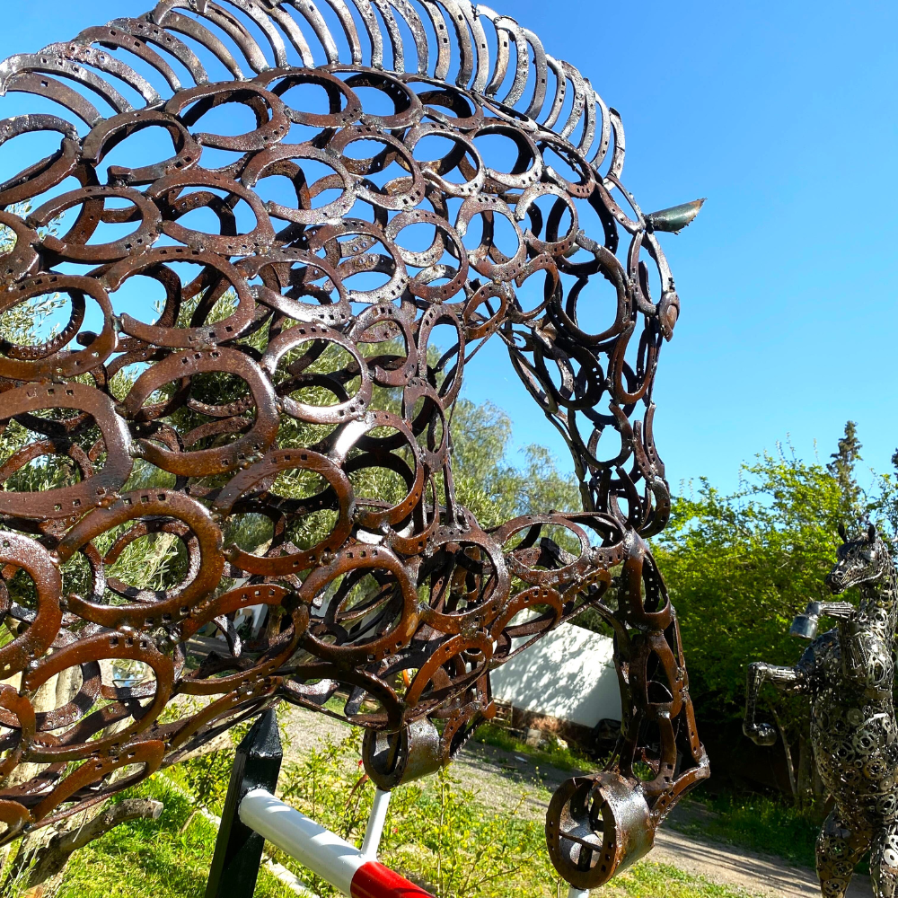 Détail tête sculpture cheval en fers à cheval recyclés avec soudures visibles et métal patiné