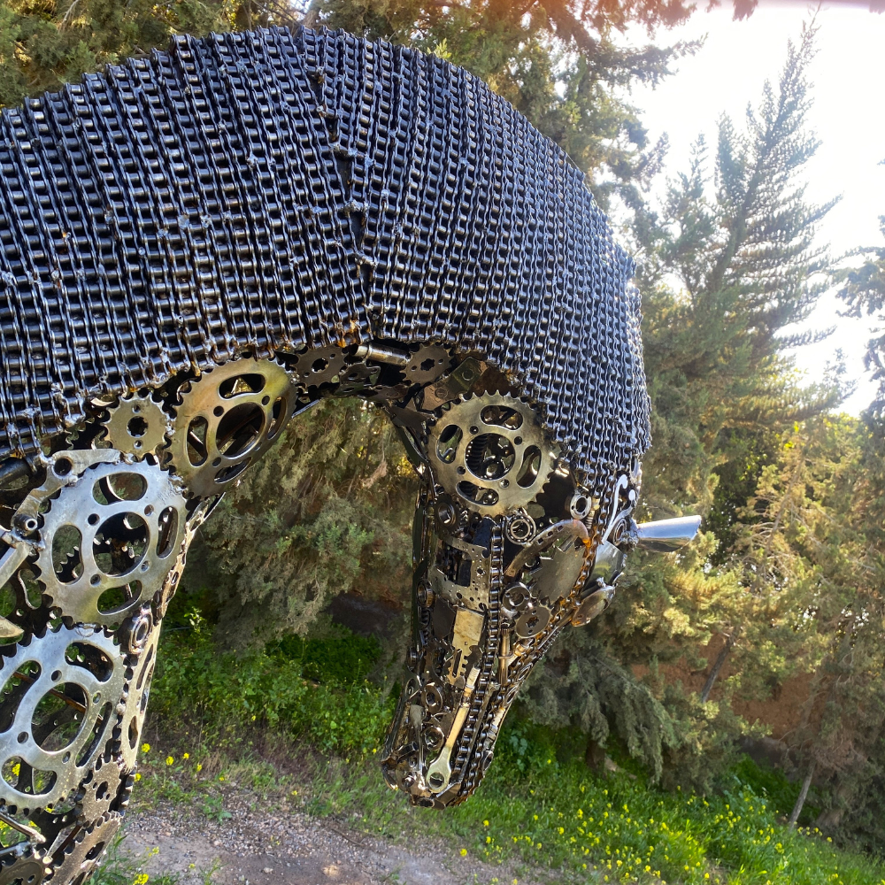 Détail tête cheval Pégase en métal recyclé avec assemblages artisanaux et reliefs métalliques visibles