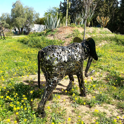 Vue arrière sculpture éléphant en métal recyclé dévoilant l’assemblage manuel des pièces métalliques