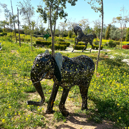 Vue côté gauche sculpture éléphant en métal recyclé montrant les reliefs du métal et les soudures visibles