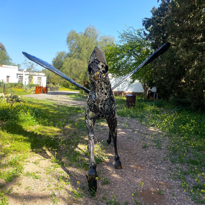 Vue de profil sculpture cheval Pégase métal recyclé avec posture au trot et ailes déployées