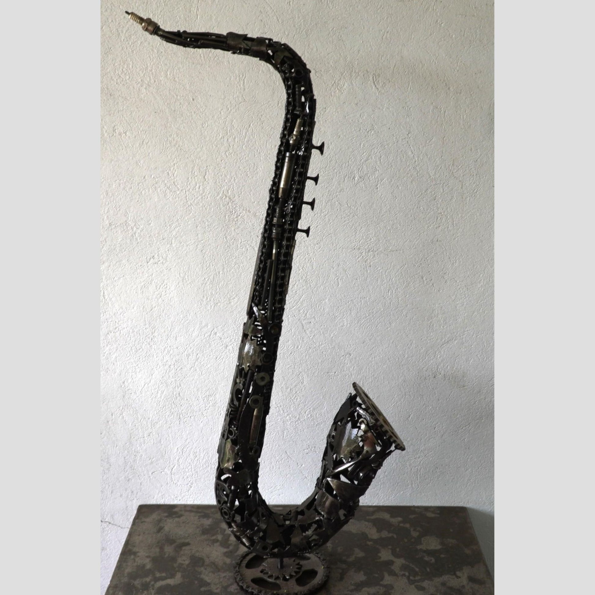 Saxophone en métal recyclé posé dans un intérieur contemporain avec finition artisanale métal brut