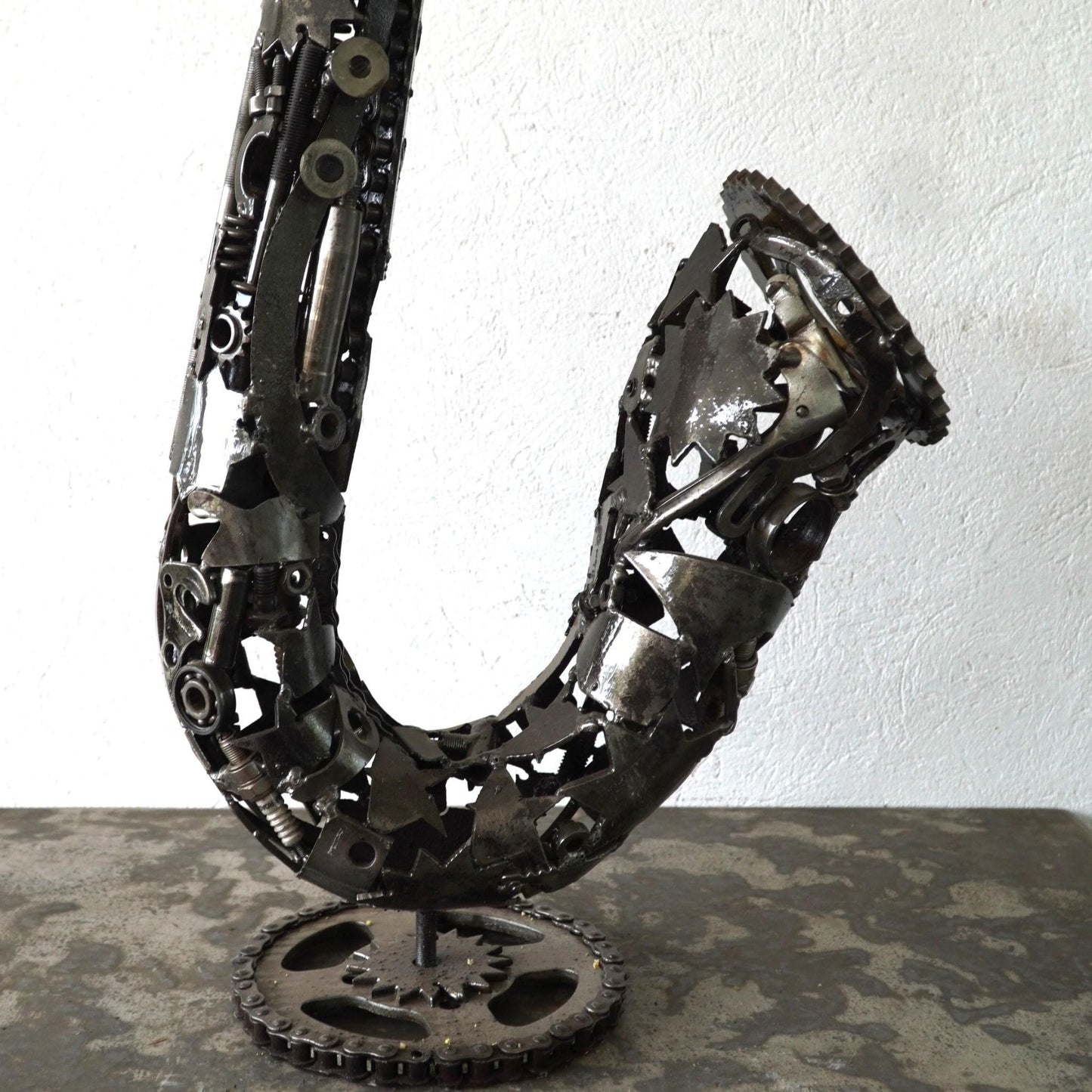 Détail culasse saxophone en métal recyclé montrant l’assemblage manuel et les reliefs métalliques