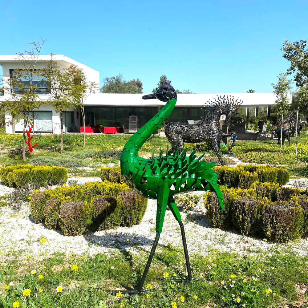 Sculpture autruche en métal recyclé installée dans un jardin avec silhouette élancée et finition brute