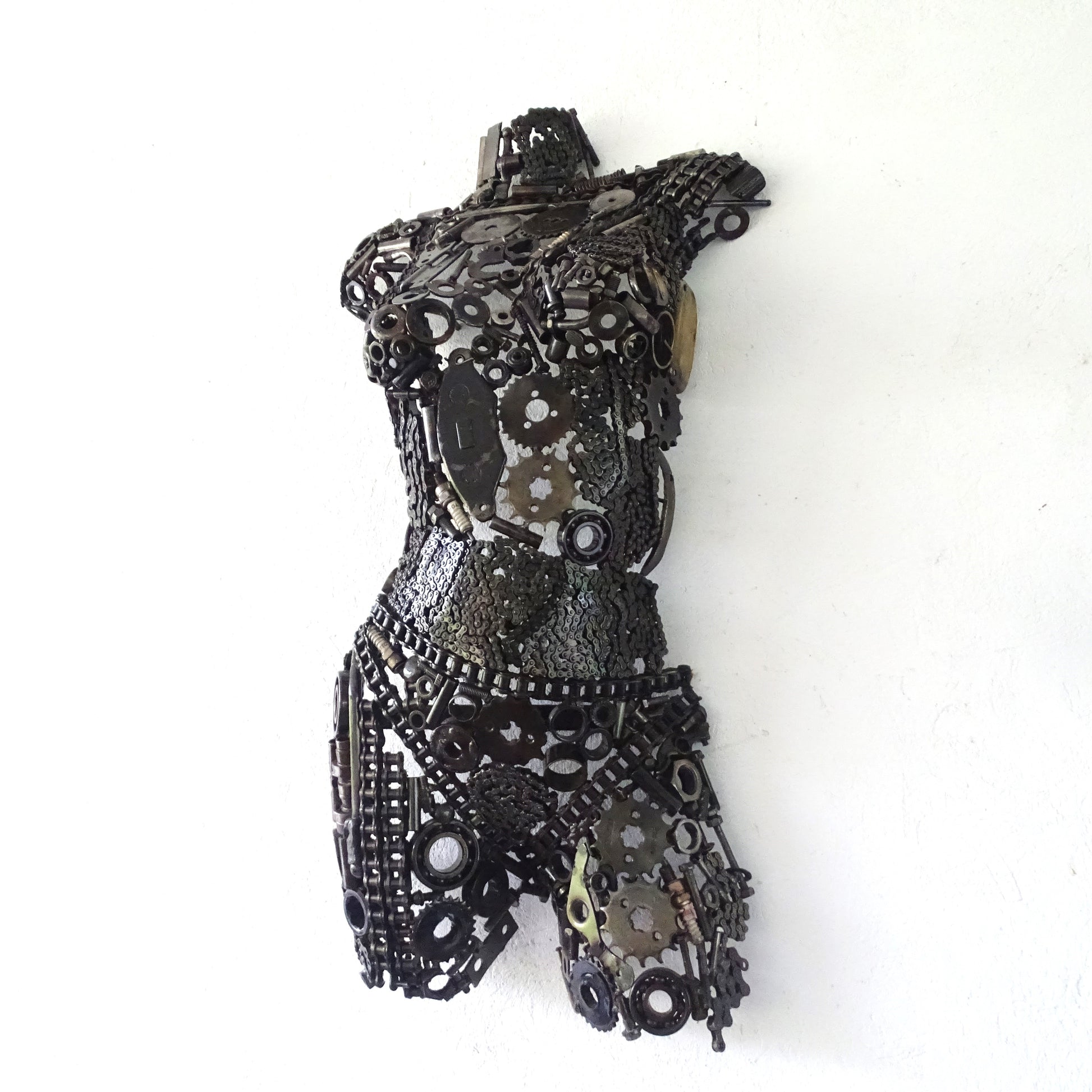 Sculpture demi-buste de femme en métal recyclé posée devant un mur de jardin, H77 x L42 cm, finition brute