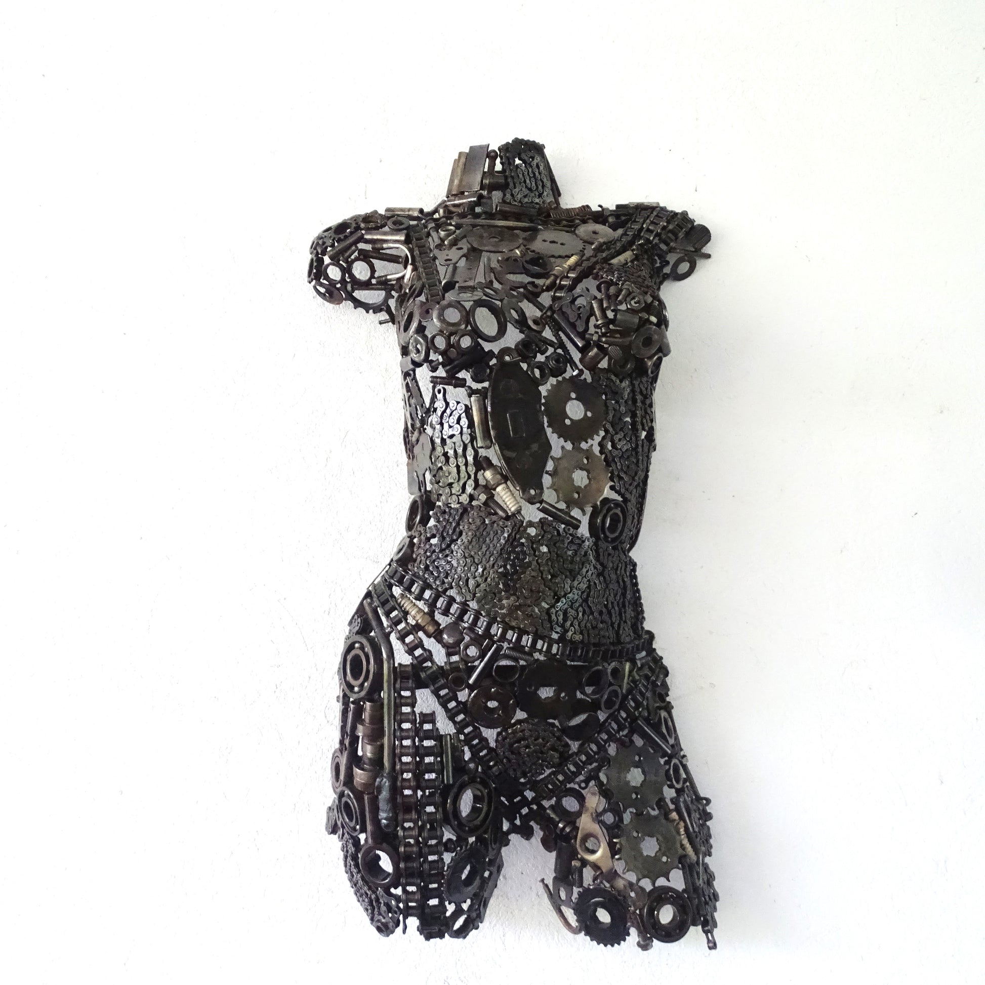 Sculpture demi-buste de femme en métal recyclé posée devant un mur de jardin, H77 x L42 cm, finition brute