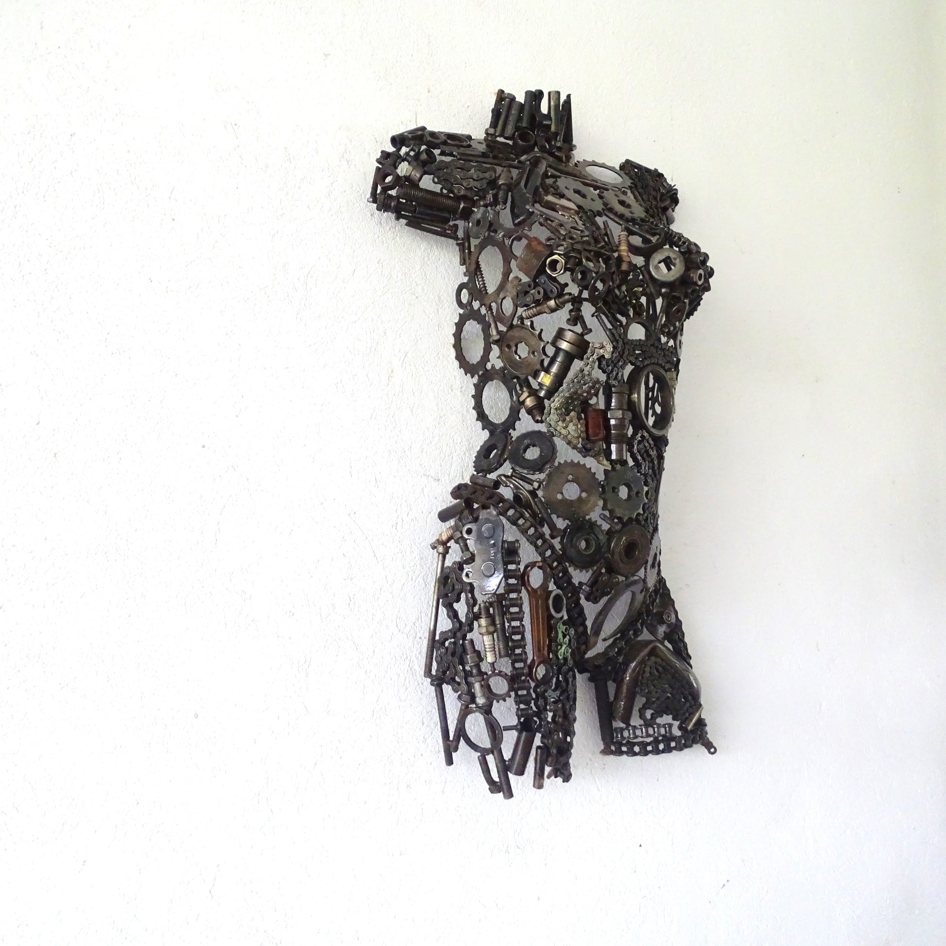 Profil latéral d'une sculpture demi-buste de femme en métal recyclé, volumes du visage modelés à la main, profondeur 18 cm