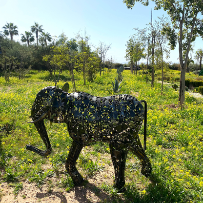 Sculpture éléphant en métal recyclé installée dans un jardin paysager avec finition métal brut artisanale