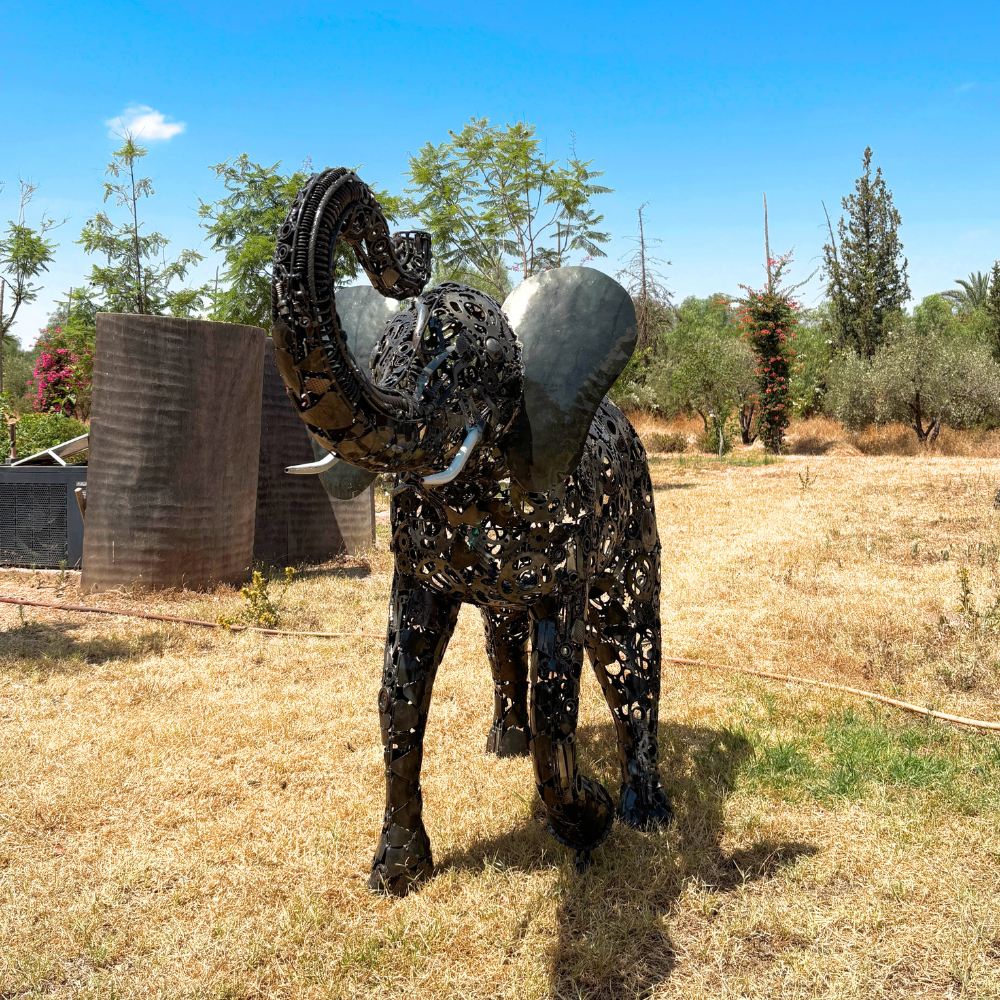 Vue avant de la sculpture éléphant en métal recyclé avec sa trompe et sa silhouette imposante