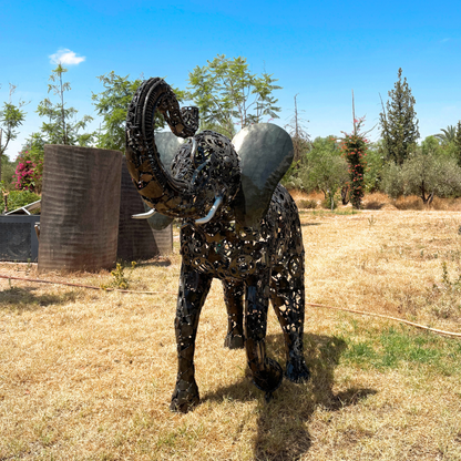 Vue avant de la sculpture éléphant en métal recyclé avec sa trompe et sa silhouette imposante