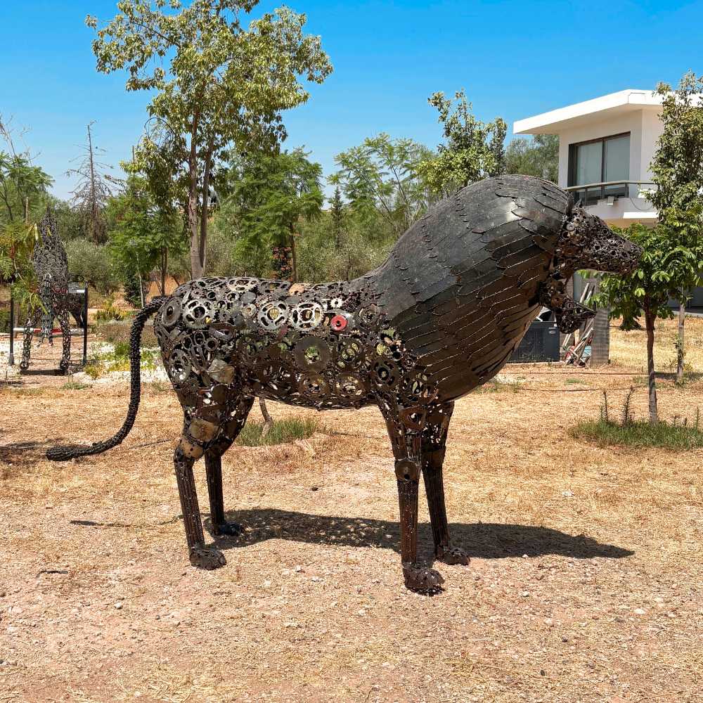 Vue gauche de la sculpture lion en métal recyclé avec détail de sa silhouette et de sa crinière
