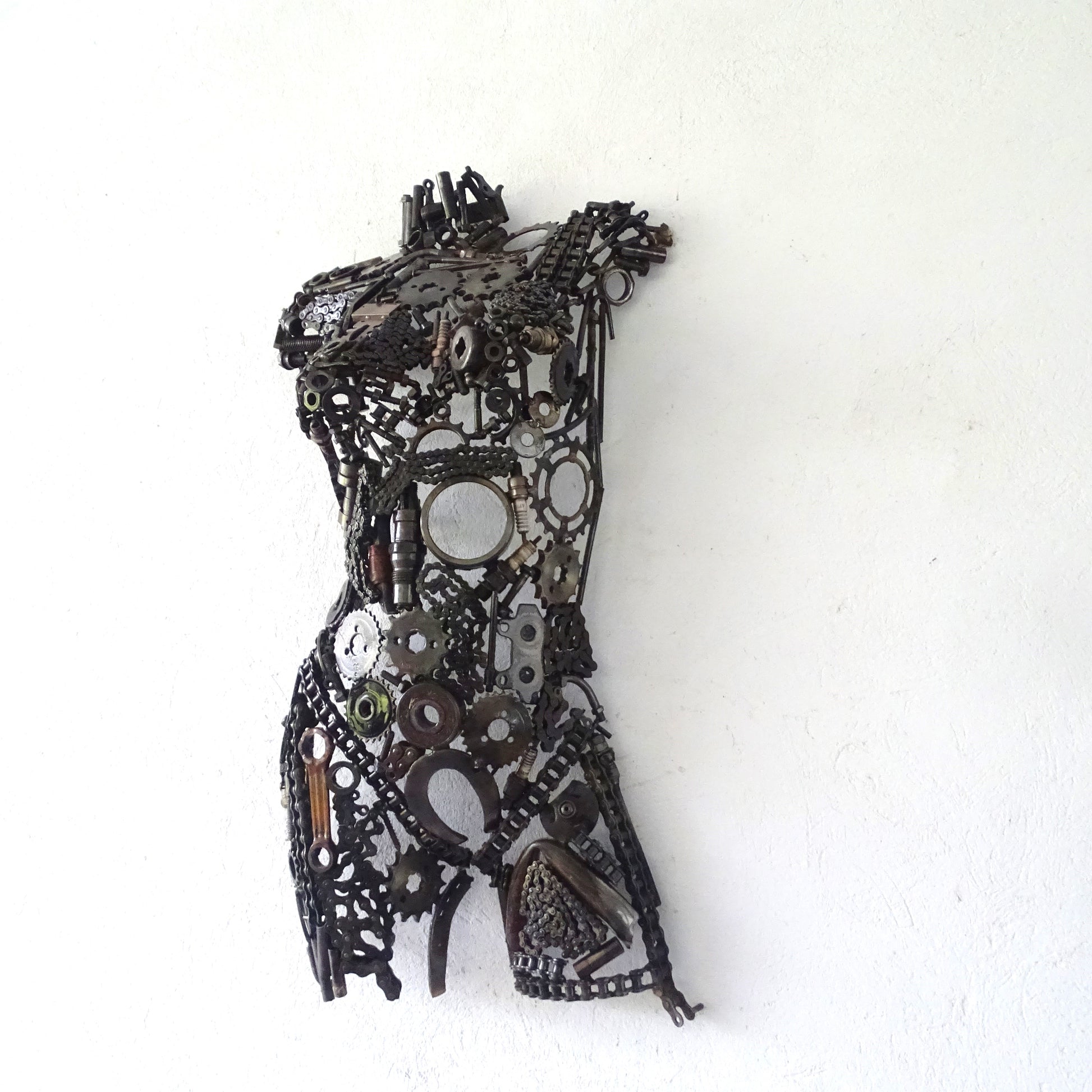 Macro sur la surface brute du métal recyclé d'une sculpture figurative, nuances chromatiques naturelles et variations de matière