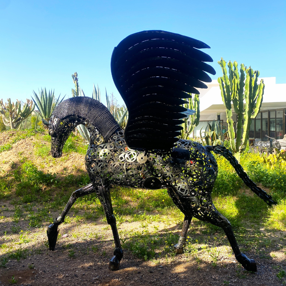 Le cheval Pégase en métal recyclé structure l’espace extérieur avec une présence artistique forte