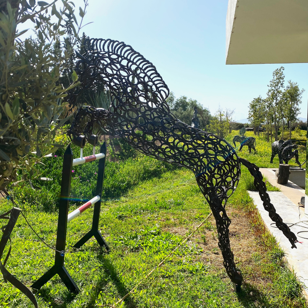 Vue latérale cheval sculpture métal recyclé avec lignes aériennes et reliefs métalliques visibles