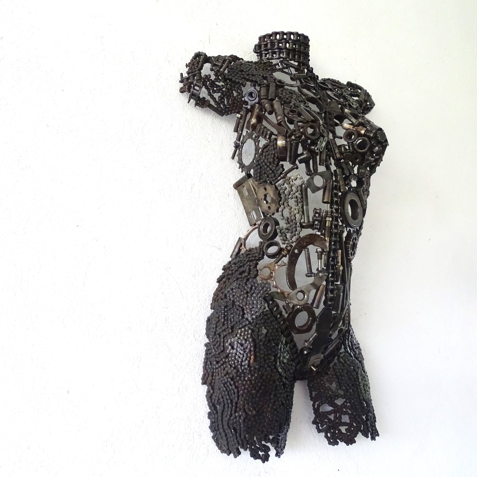 Vue latérale sculpture demi-buste femme en métal recyclé avec lignes contemporaines et patine brute